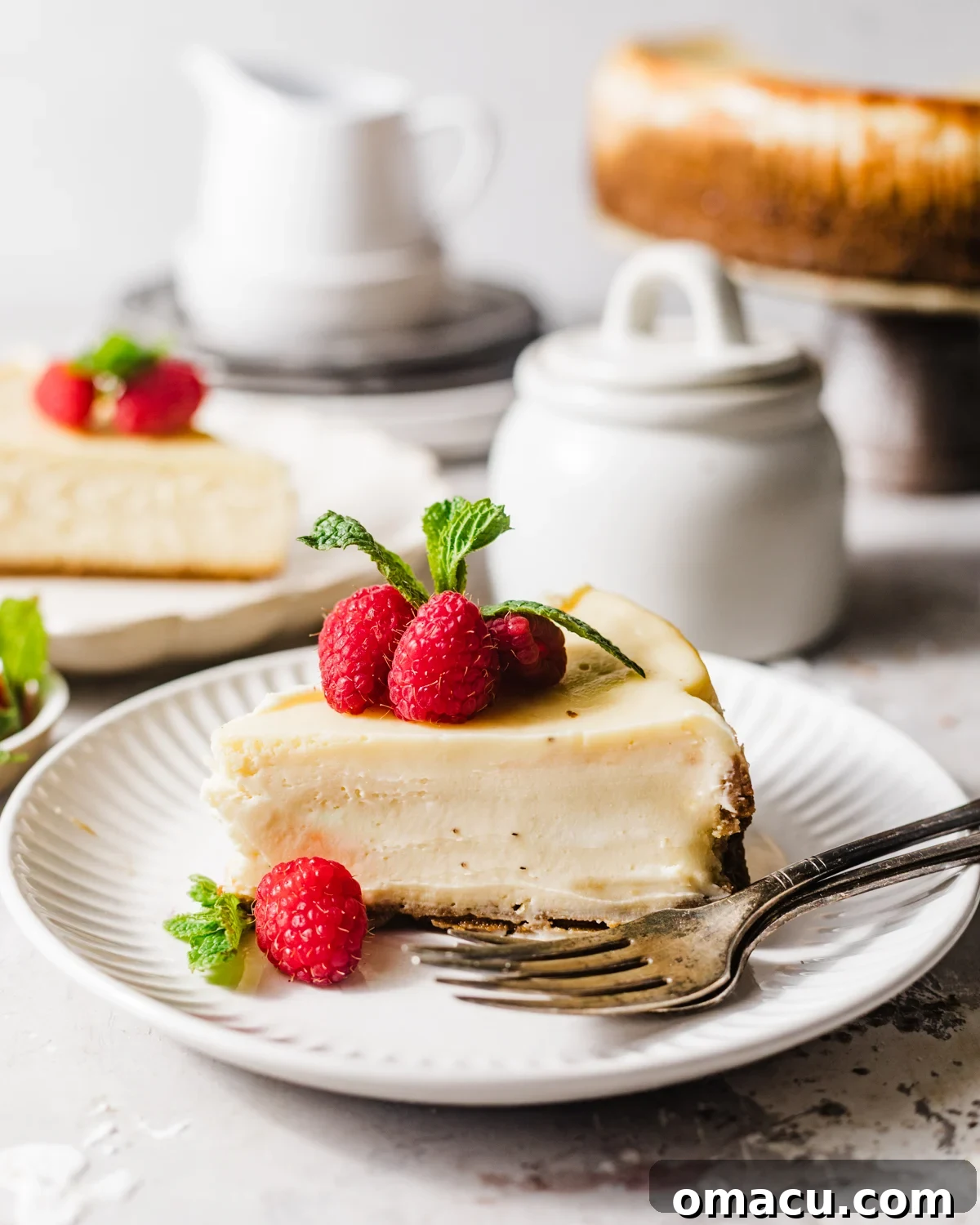 Multiple slices of mascarpone cheesecake on individual plates, ready to be enjoyed with forks.