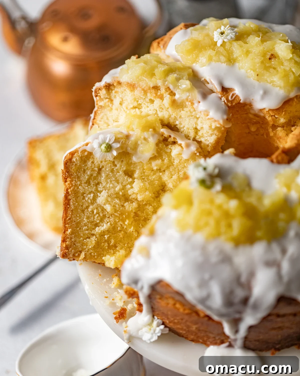 Several slices of cream cheese pineapple pound cake arranged beautifully on a cake stand, showcasing its moist texture and golden crust.