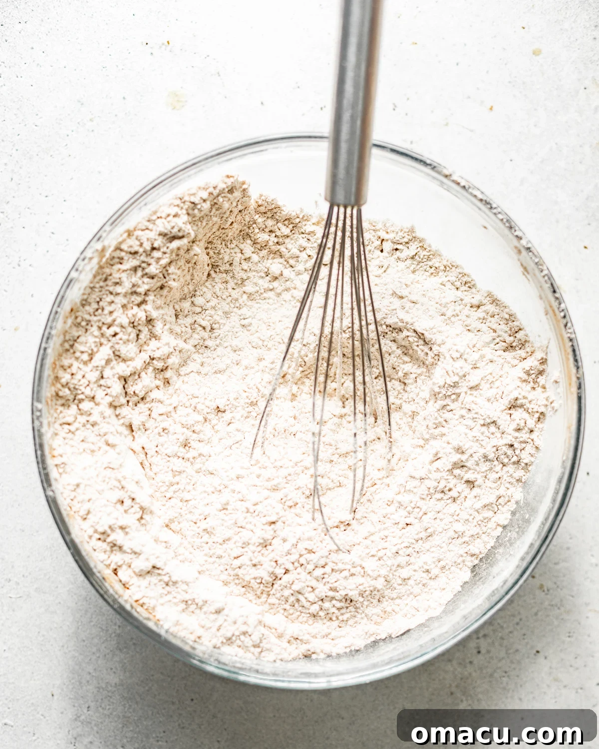 Cake flour, baking powder, and salt are whisked together in a separate bowl, ensuring all dry ingredients are evenly distributed.