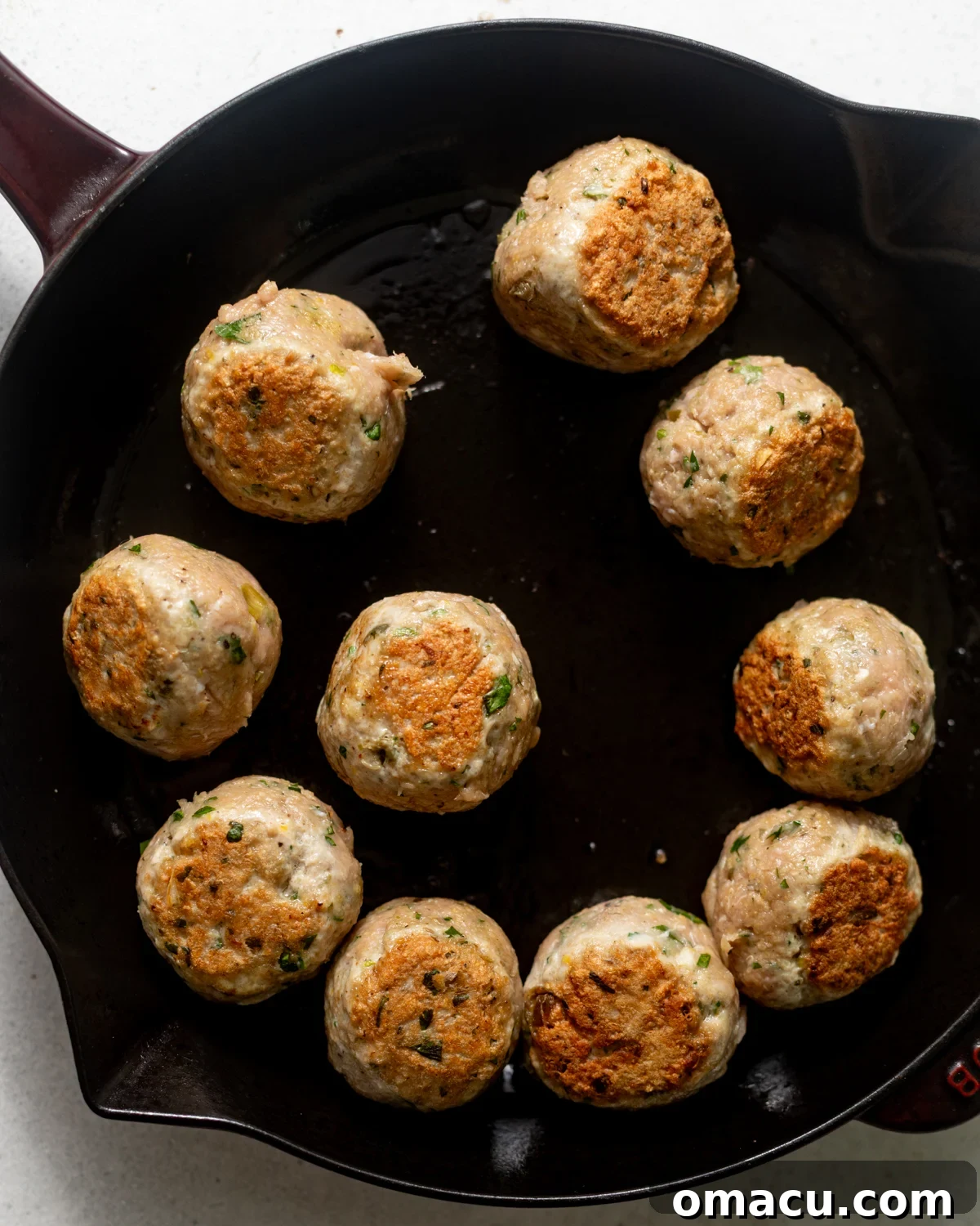 seared meatballs in a skillet.
