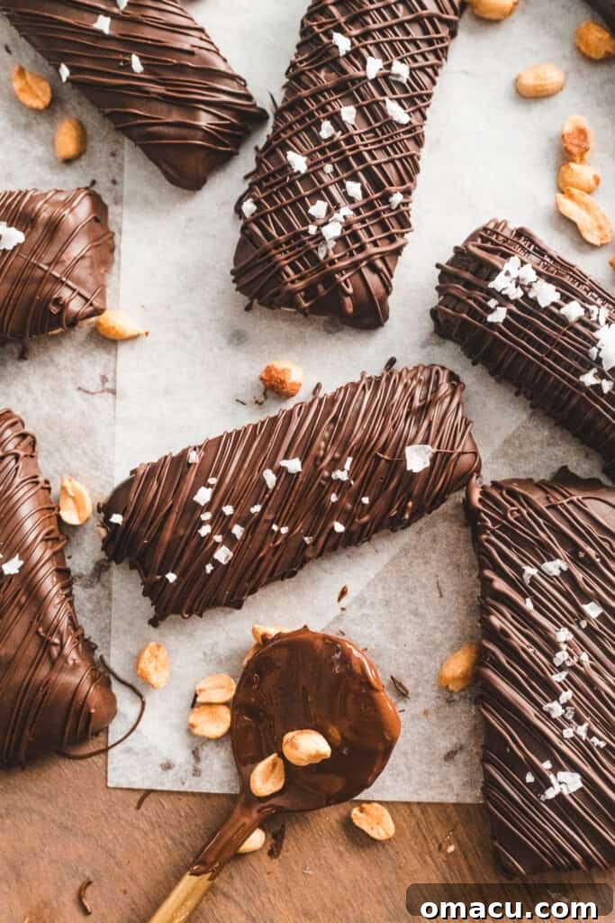 Gooey homemade caramel being poured over the chilled nougat and peanut layer in a square pan.
