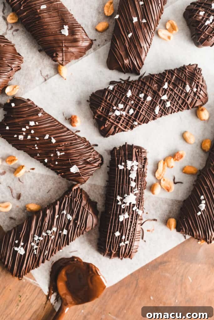 Finished homemade Snickers bars, beautifully coated in chocolate and ready to serve.