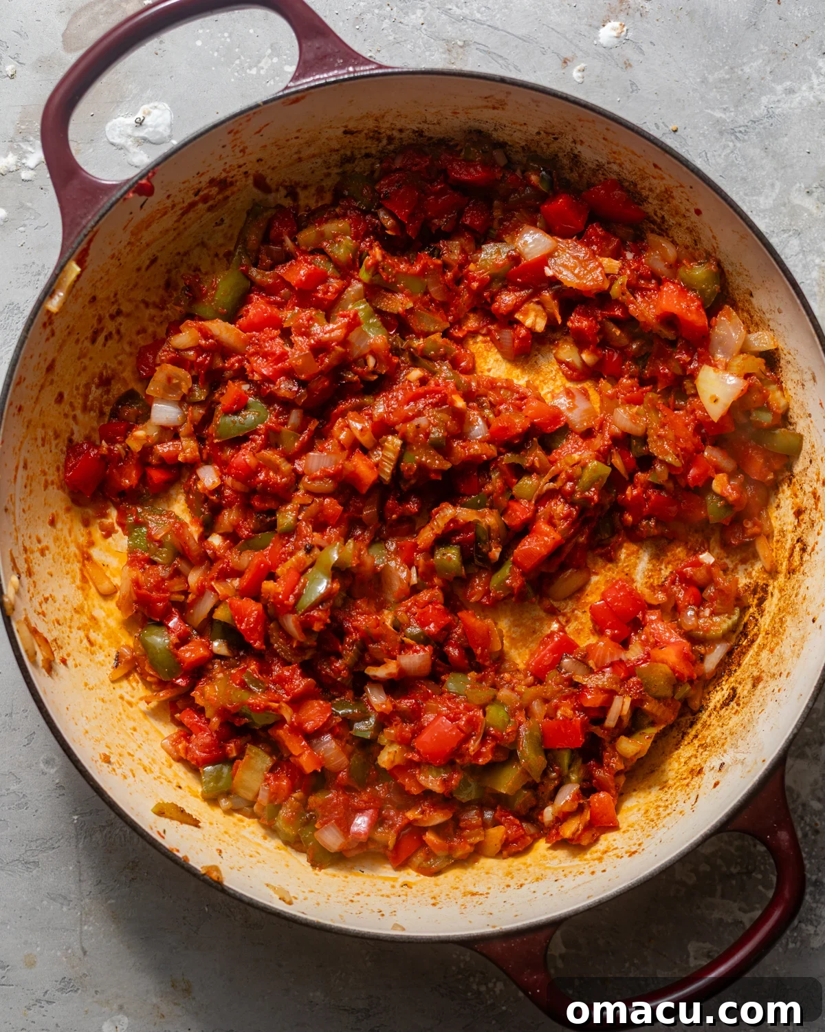 onion, bell pepper, garlic, celery, seasonings, tomato paste, and stewed tomatoes in a large skillet.
