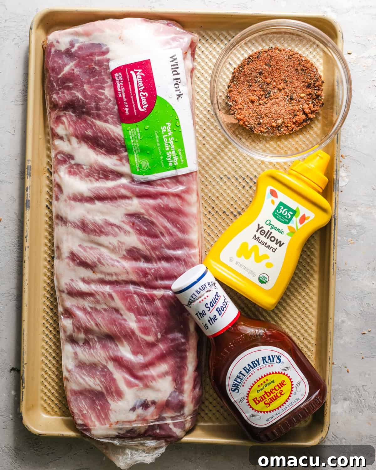 Ingredients laid out: St. Louis style ribs, barbecue sauce, yellow mustard, various spices, and apple juice.