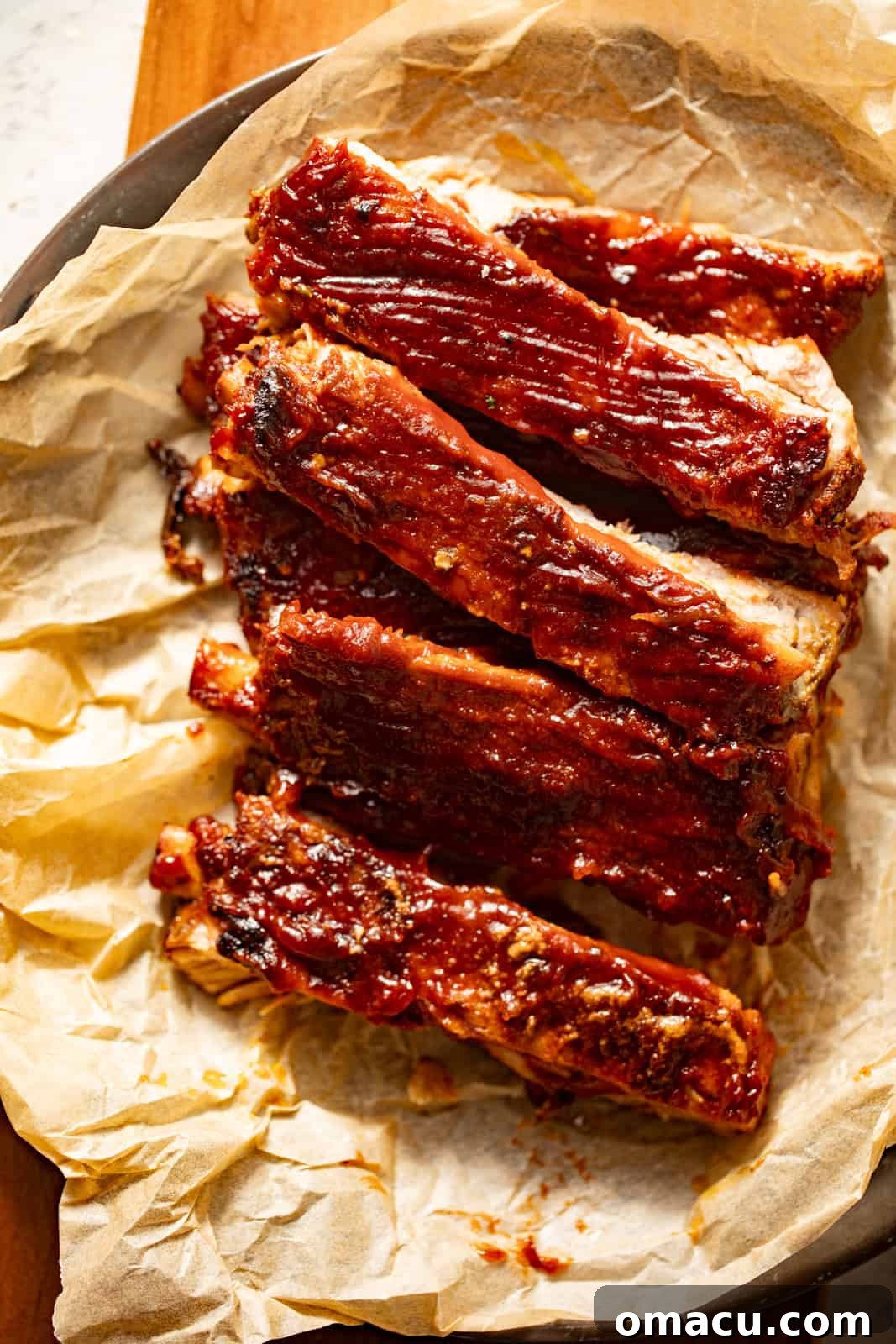 Slices of tender, sauced ribs arranged on a serving platter.