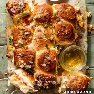 bacon chicken ranch sliders on a serving tray with garlic butter on top.