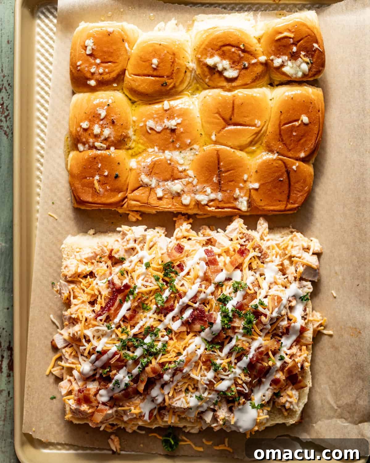 slider buns cut in half with the chicken mixture on top and a drizzle of ranch and bacon bits on top. 