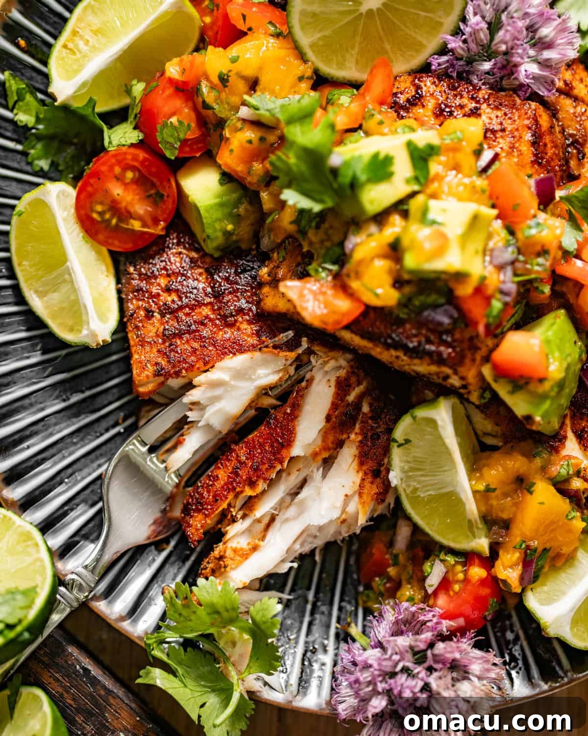 A close-up view of a perfectly cooked blackened Mahi Mahi fillet, generously topped with fresh peach salsa, presented on a white plate, highlighting its vibrant colors and delicious textures.