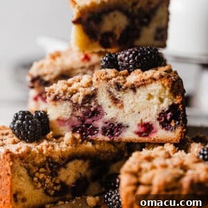 Sliced blackberry coffee cake on a plate stacked on top of each other.