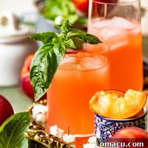 Two glasses of peach lemonade garnished with fresh mint.