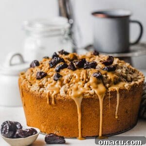 A beautiful vintage prune cake on a table, with rich dulce de leche drizzled on top, garnished with chopped prunes, ready to be served.