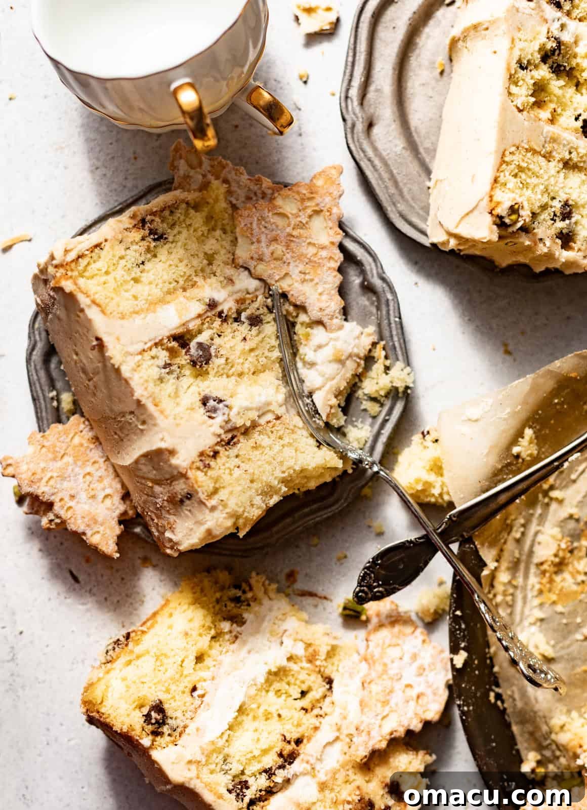 A stunning slice of cannoli cake on a plate with a fork, showing off its beautiful layers and rich filling.