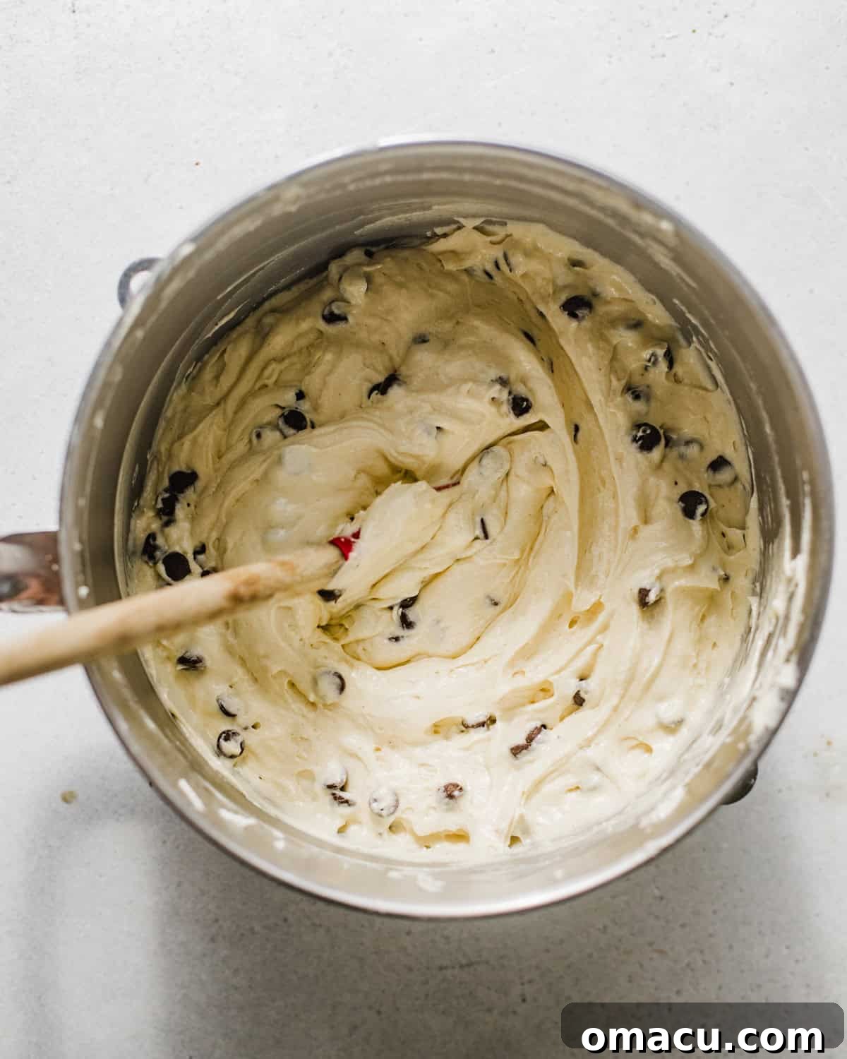 Cake batter with mini chocolate chips evenly mixed into the smooth, pale yellow batter.