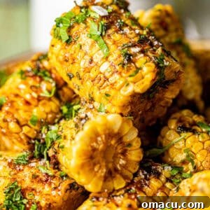 Cajun corn on the cob stacked on top of each other covered in garlic butter.