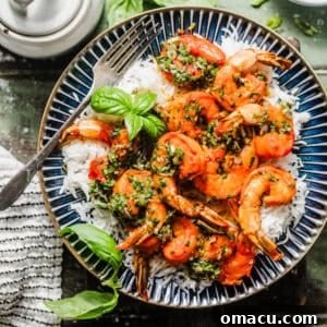 shrimp chimichurri on a plate on top of white rice and topped with fresh basil.
