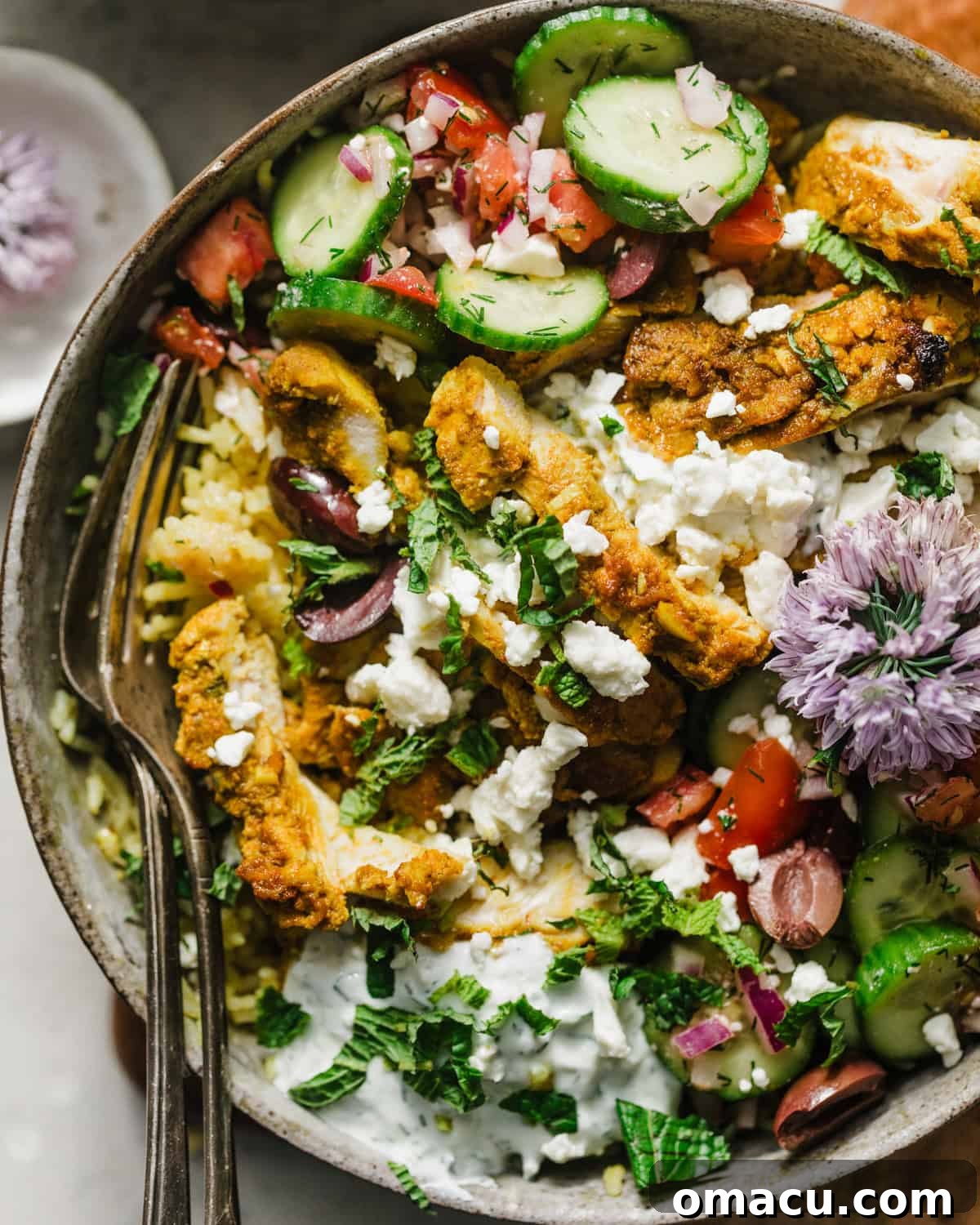 Close-up photo of the vibrant ingredients for Mediterranean chicken bowls, featuring fresh vegetables, herbs, and chicken ready for marinating.