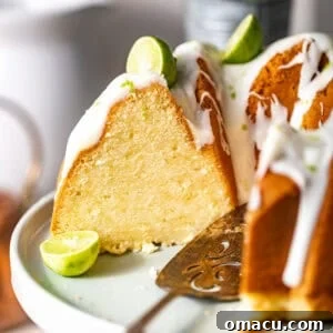 Key lime pound cake sliced on a cake stand with a cake knife.