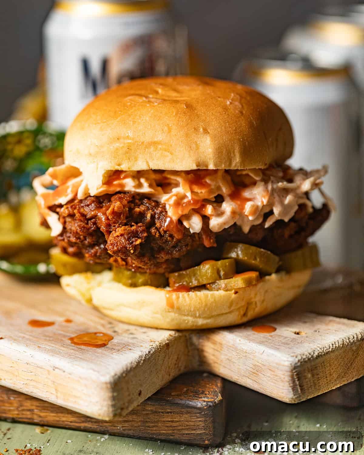 nashville hot chicken sandwich on a wood serving board. 