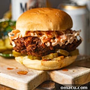 nashville hot chicken sandwich on a wood serving board.