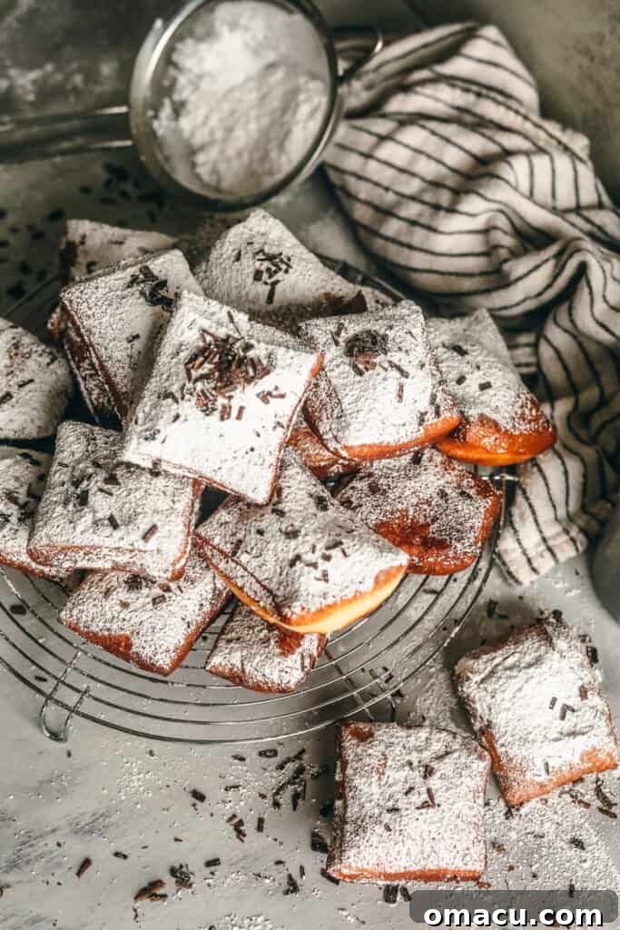 New Orleans Style Beignets on a table with powdered sugar and chocolate shavings