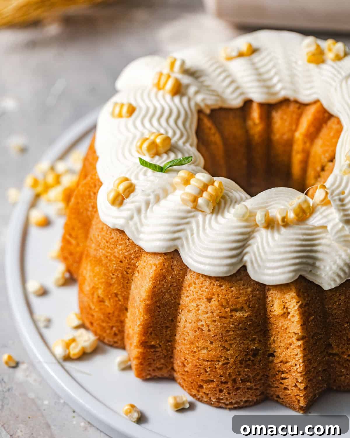overhead photo of corn pound cake on a cake plate with honey buttercream on top.