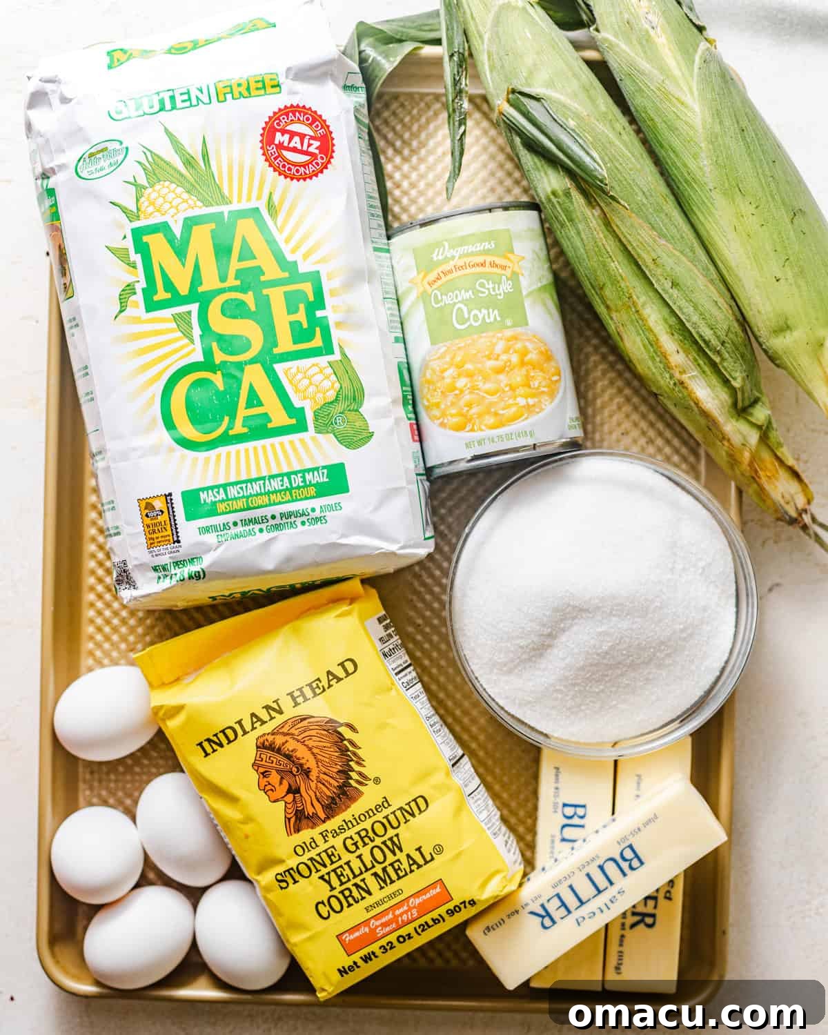 ingredients to make corn cake - butter, sugar, eggs, fresh corn, masa harina, all purpose flour, cornmeal, creamed corn, baking soda, baking powder, and kosher salt.