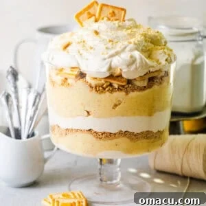 banana pudding from scratch in a trifle bowl topped with chessman cookies and fresh bananas.