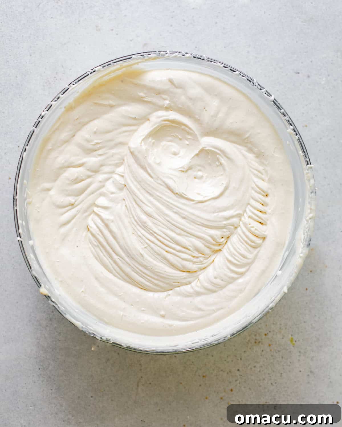 A large mixing bowl containing the freshly whipped banana-infused cream, light and fluffy, ready for assembly.
