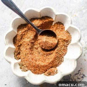 Homemade Cajun seasoning in a bowl with spoon.