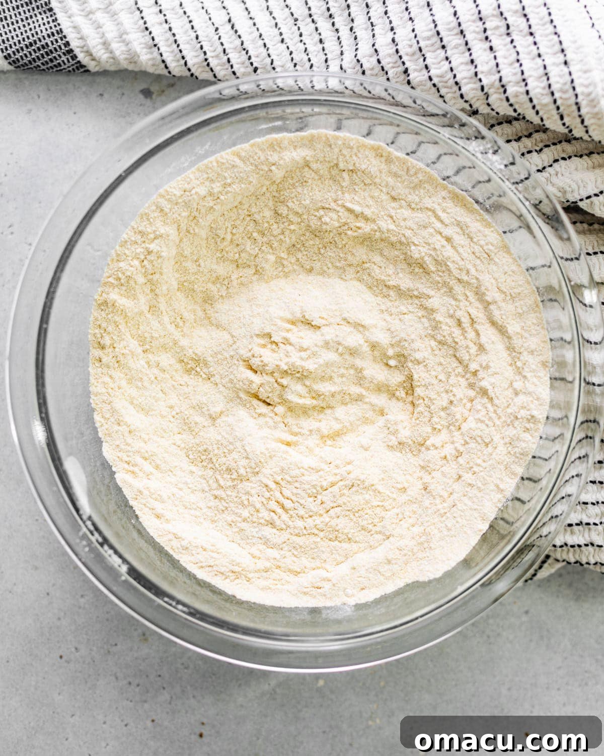 Dry ingredients for hush puppies being whisked together in a large mixing bowl.