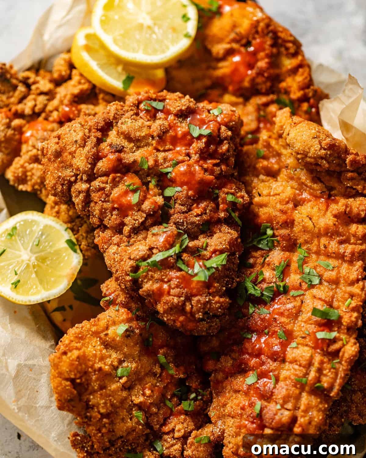 An overhead shot of a vibrant platter piled high with crispy golden fried catfish, garnished with fresh herbs and lemon, surrounded by delicious Southern sides.