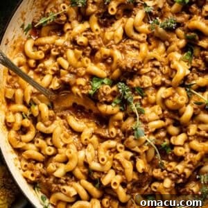 Up close photo of homemade hamburger helper in a pot, showing the creamy, cheesy sauce and tender macaroni.
