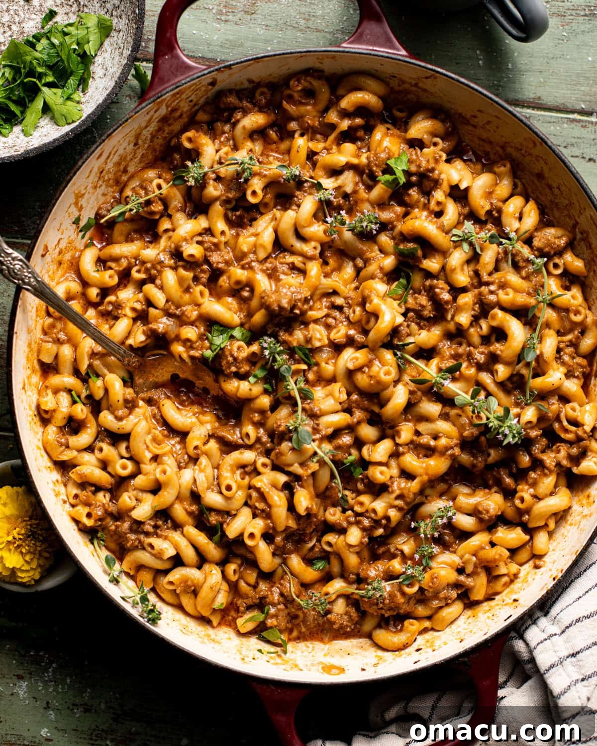 A close-up shot of homemade Hamburger Helper in a pot, topped with vibrant fresh herbs, ready for serving.