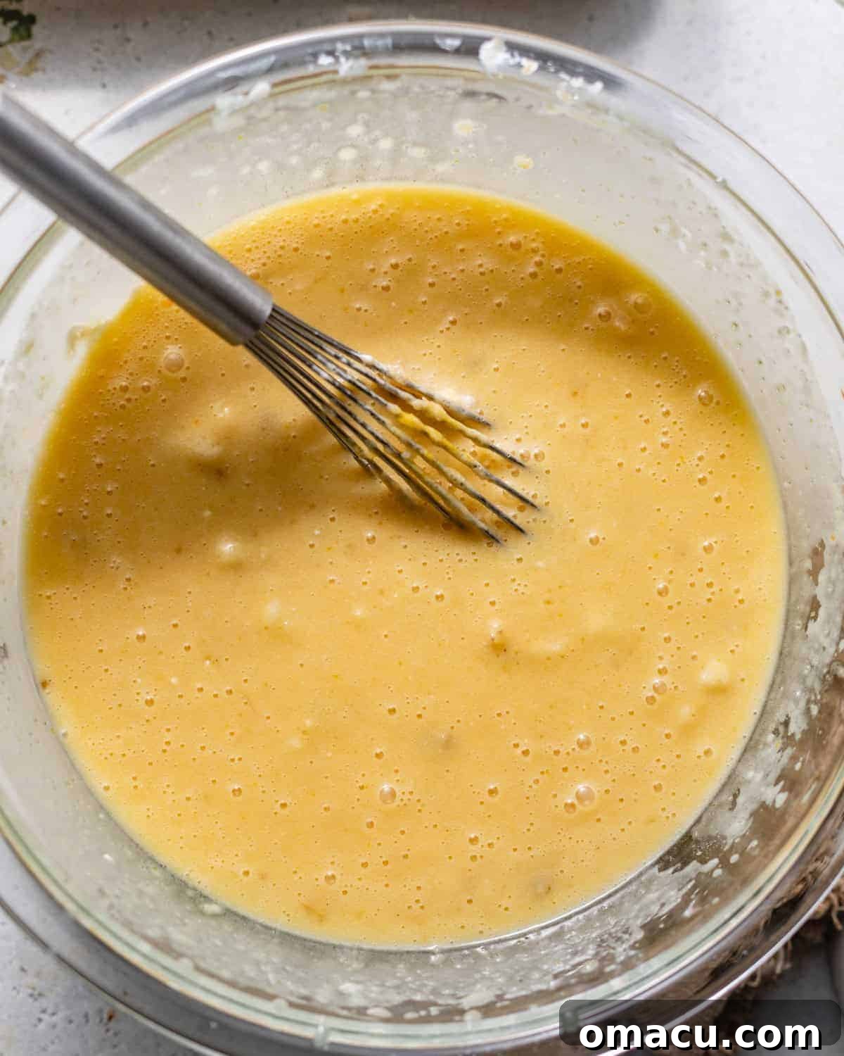 Wet ingredients, including melted butter, sugar, buttermilk, oil, eggs, and various extracts, thoroughly whisked in a large bowl.