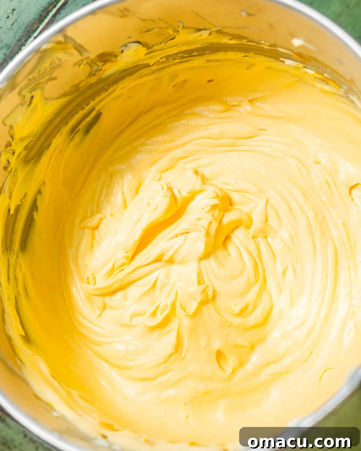 A large mixing bowl filled with the vibrant orange mango mousse mixture, perfectly combined and ready for the next step.