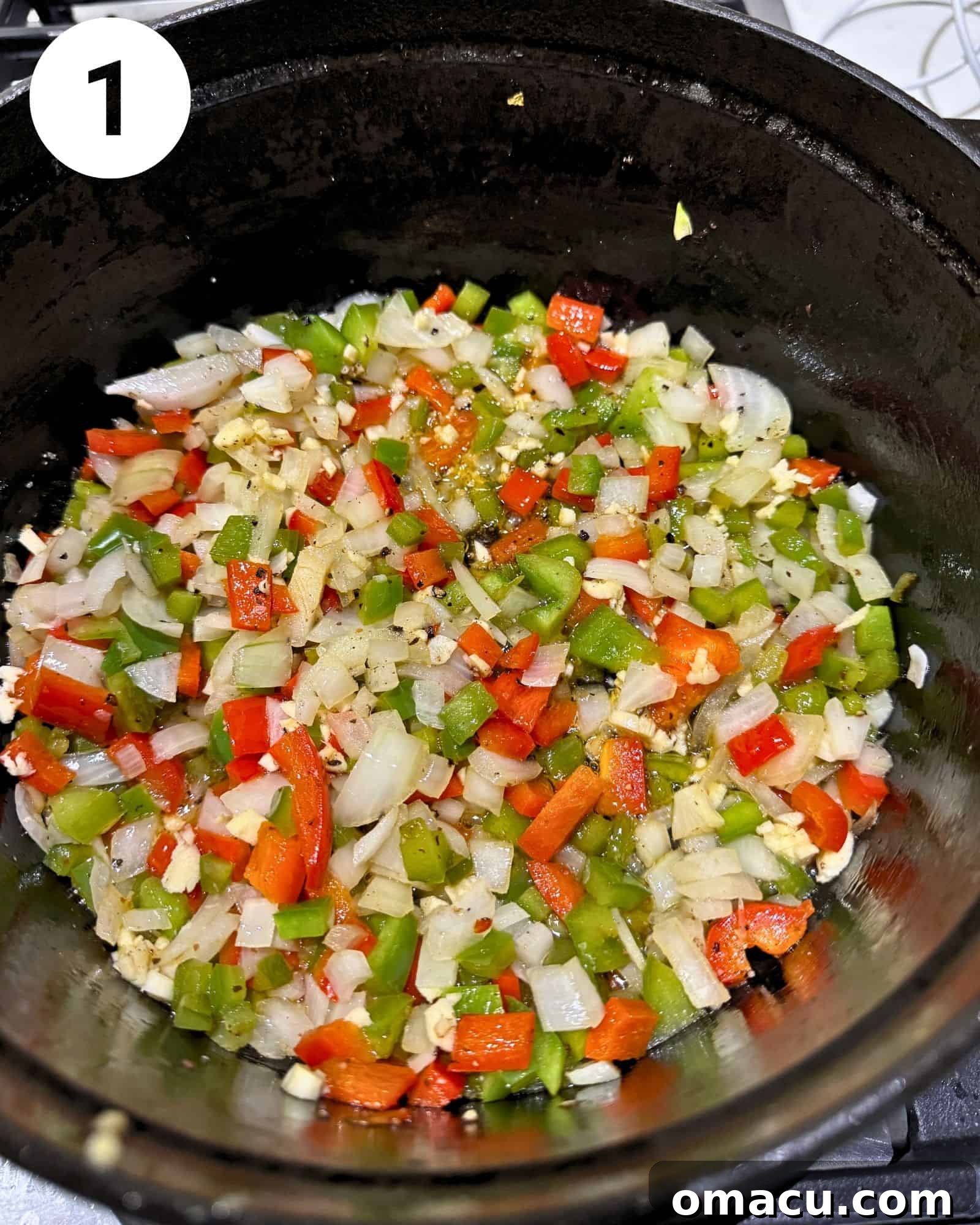 Diced bell peppers, onions, garlic, and seasoning blend sizzling gently in a Dutch oven, creating an aromatic base for the chili.