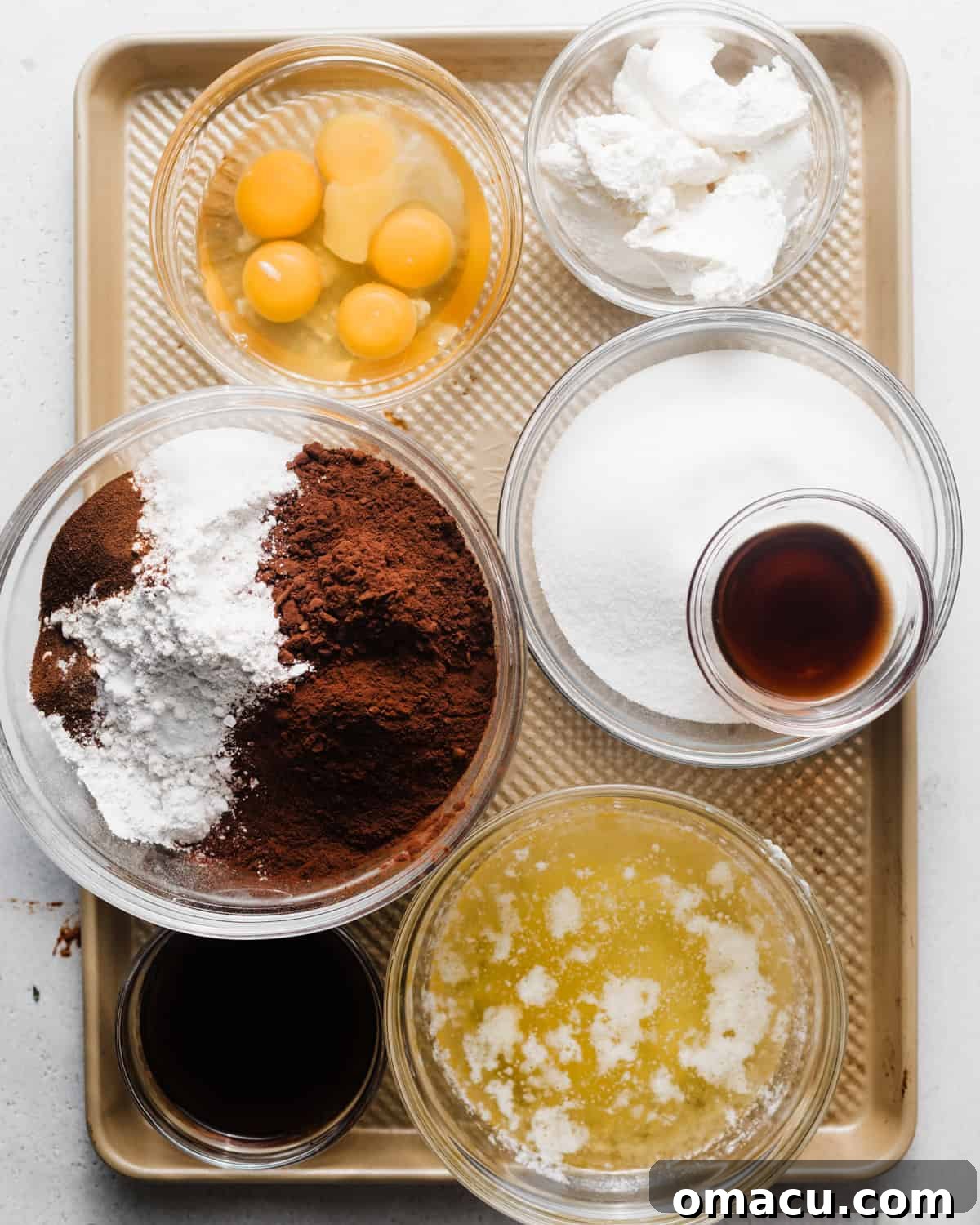 A vibrant flat lay showcasing all the essential ingredients needed to bake the perfect chocolate ricotta cake: melted butter, vegetable oil, fresh eggs, an extra egg yolk, granulated sugar, fine cake flour, baking powder, baking soda, hot coffee, aromatic espresso powder, rich cocoa powder, and creamy ricotta cheese.