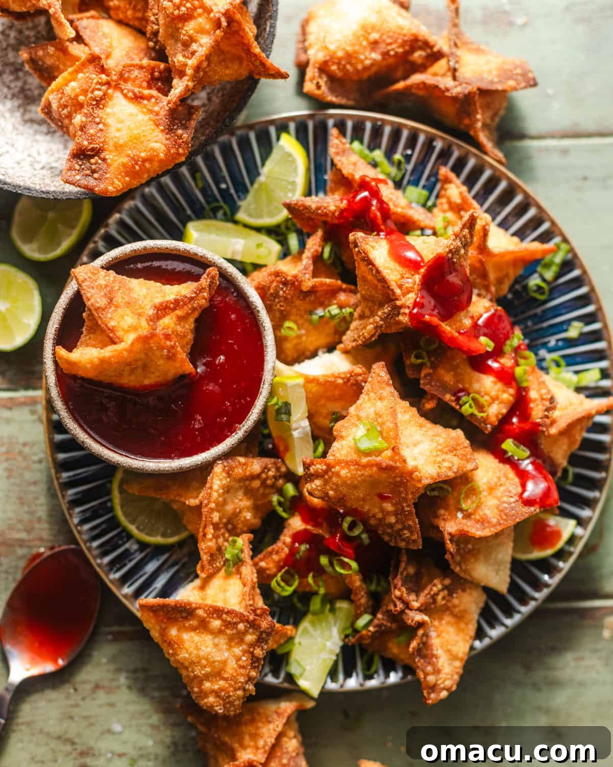overhead photo of crab rangoons on a plate with homemade sweet and sour sauce in a bowl. 