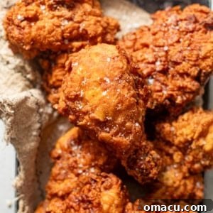 A piece of crispy buttermilk fried chicken in a serving basket, ready to eat.