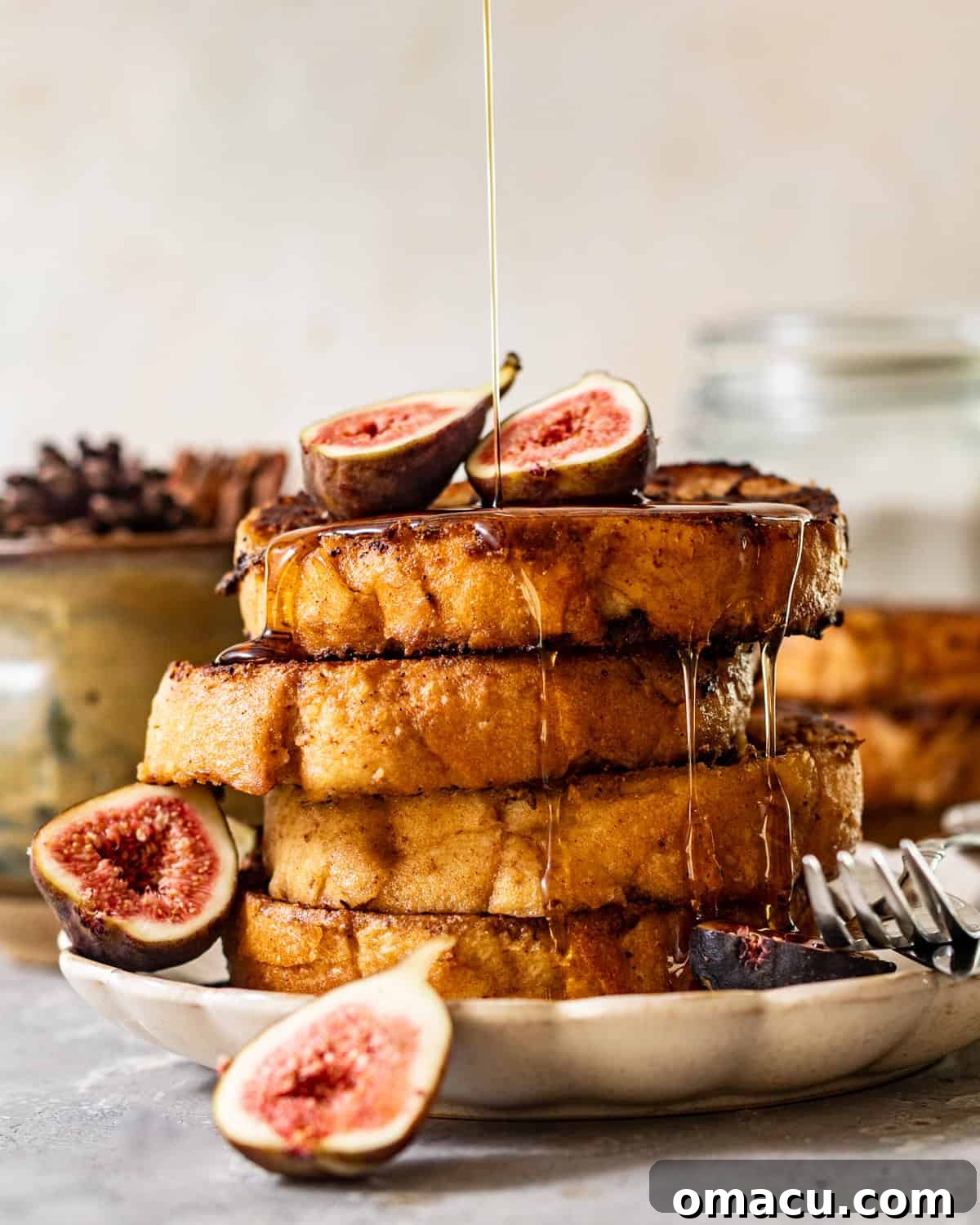 Golden-brown sourdough French toast drizzled generously with maple syrup and garnished with fresh sliced figs.