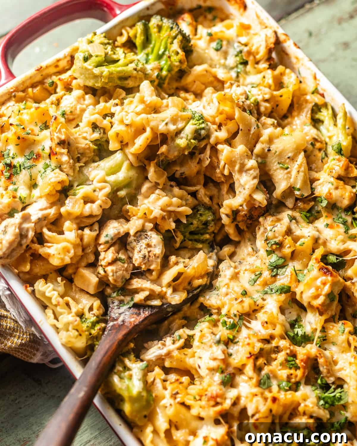 overhead photo of baked chicken and broccoli alfredo in a baking dish with a spoon.