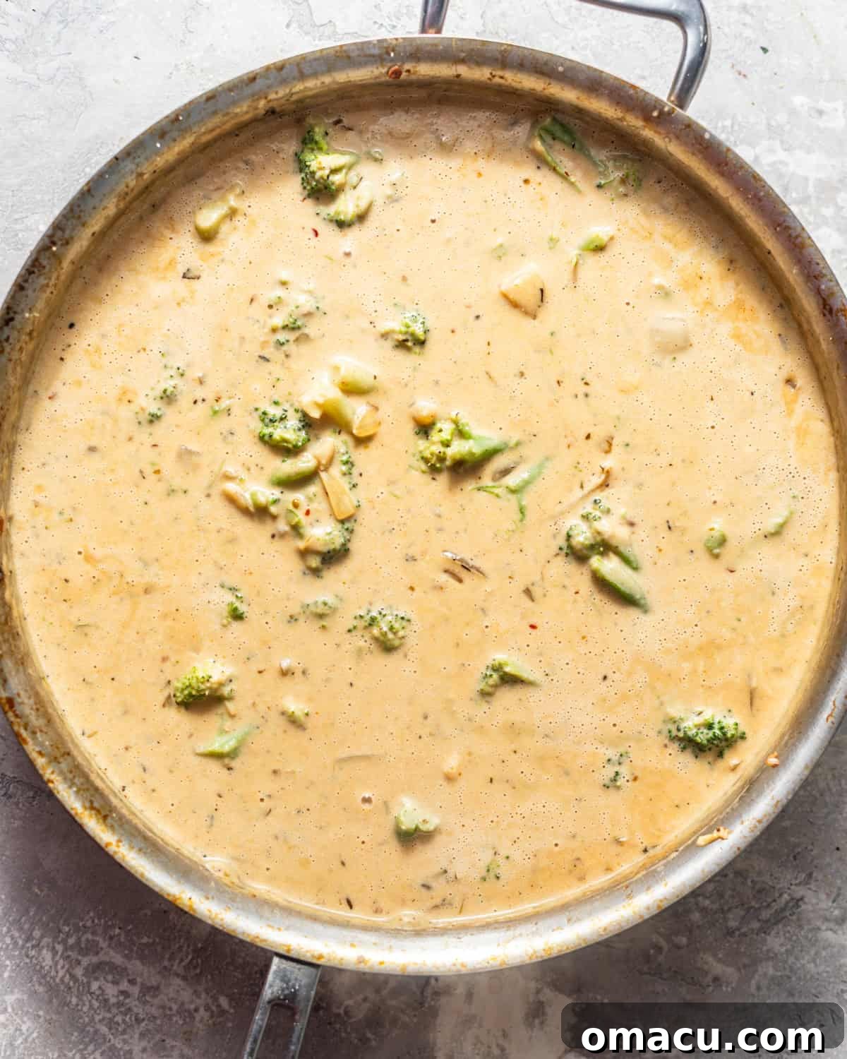 alfredo sauce in a pan with broccoli. 