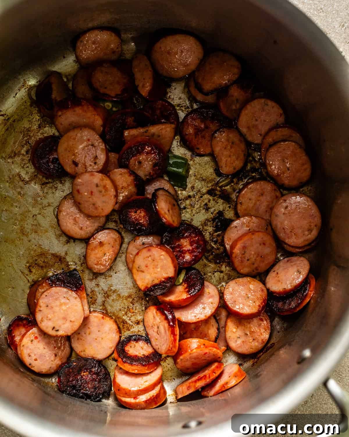 sliced andouille sausage seared in a pan. 