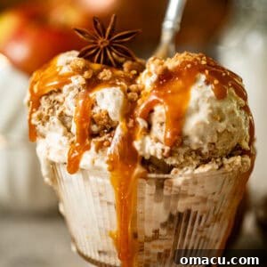 apple pie ice cream in a cup with salted caramel sauce drizzled on top.
