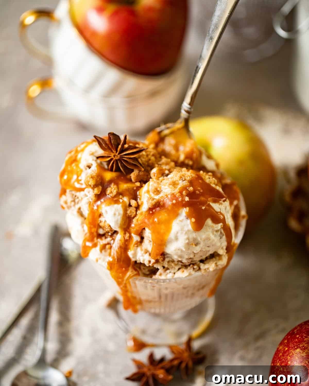 overhead photo of apple pie ice cream in a glass with a spoon.
