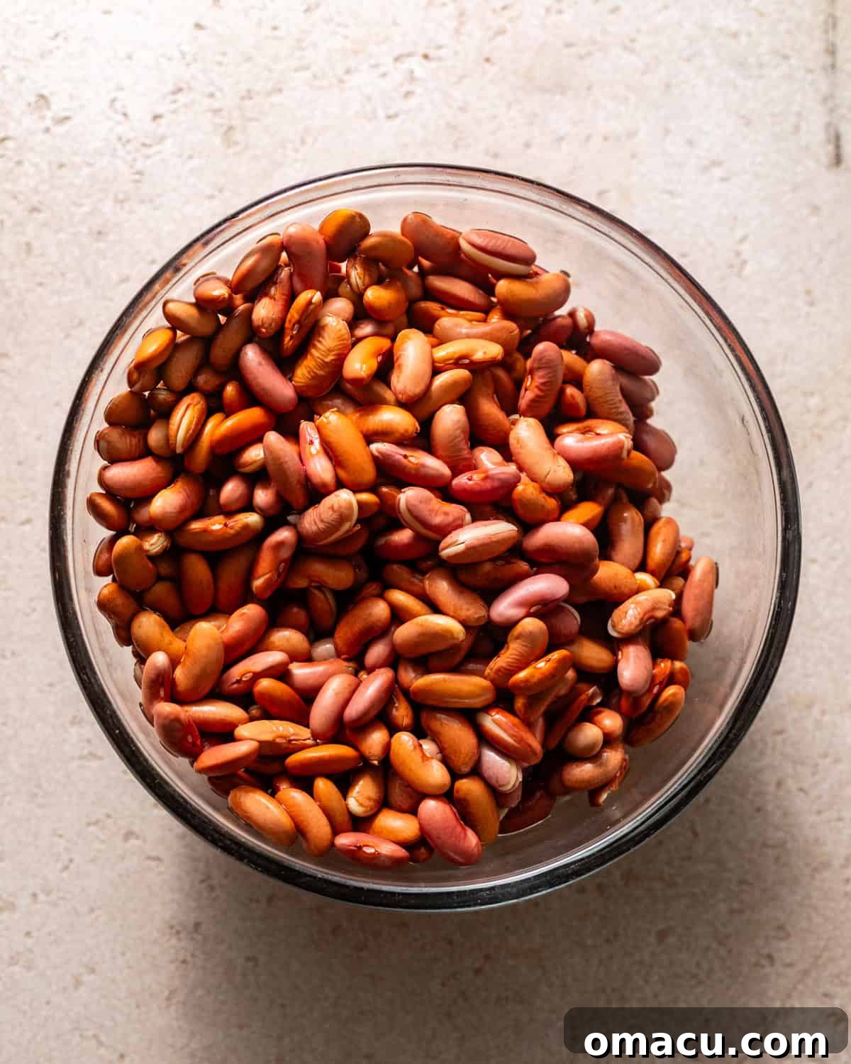 Dry kidney beans soaking in a bowl of water.