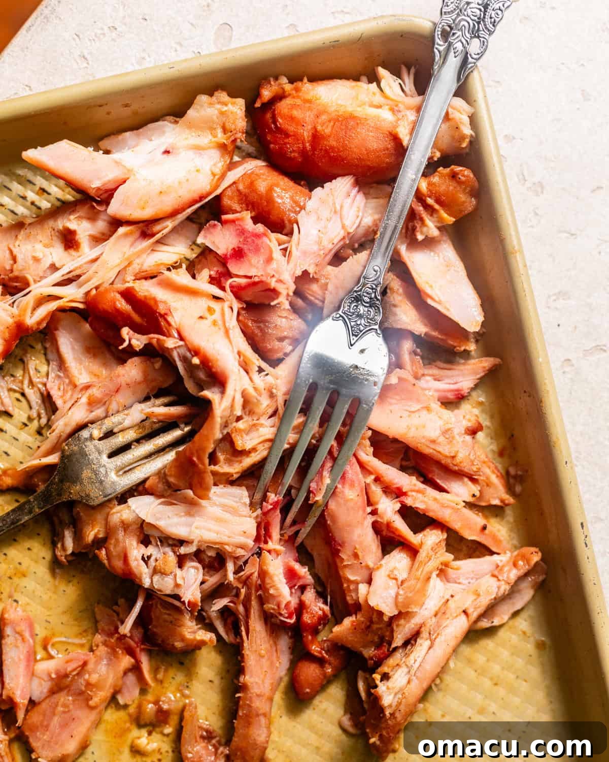 Shredded smoked turkey leg meat on a baking sheet, ready to be added back into the red beans.