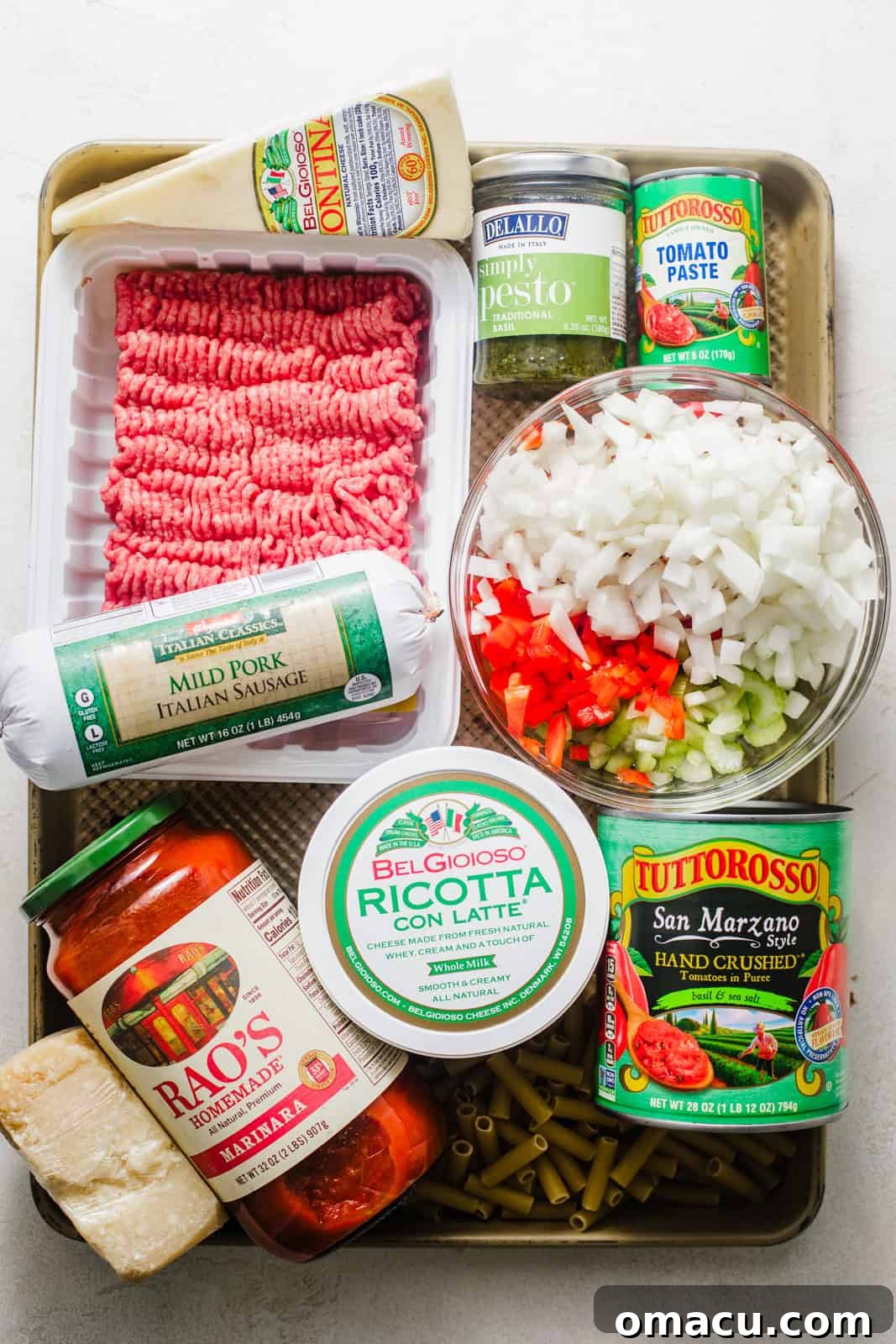 A collection of fresh ingredients laid out on a baking tray, ready to be transformed into baked ziti with ricotta.
