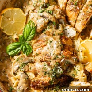 Chicken Marsala Fettuccine in a skillet garnished with basil.