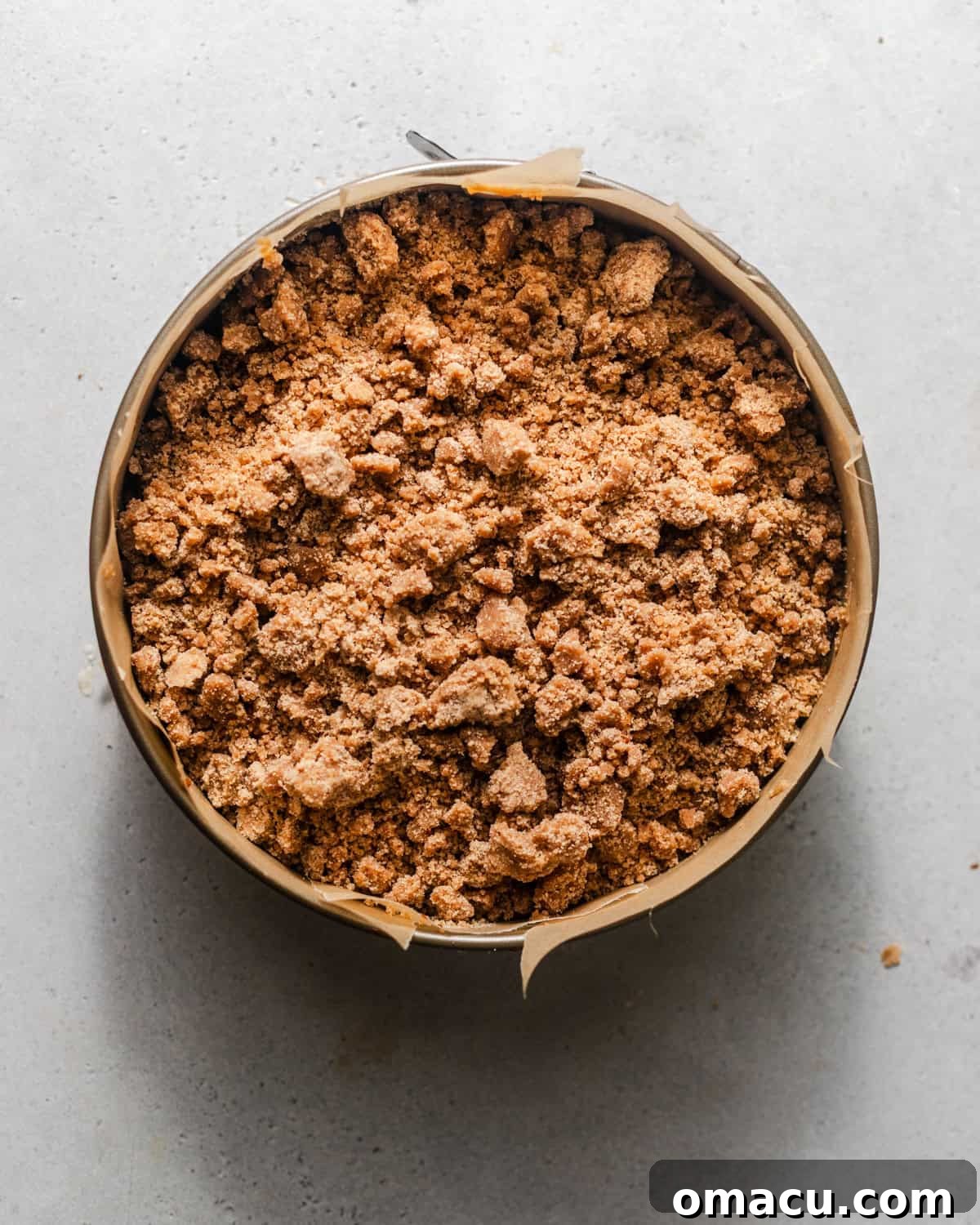 Assembled apple coffee cake with streusel topping in a springform pan, ready for baking.